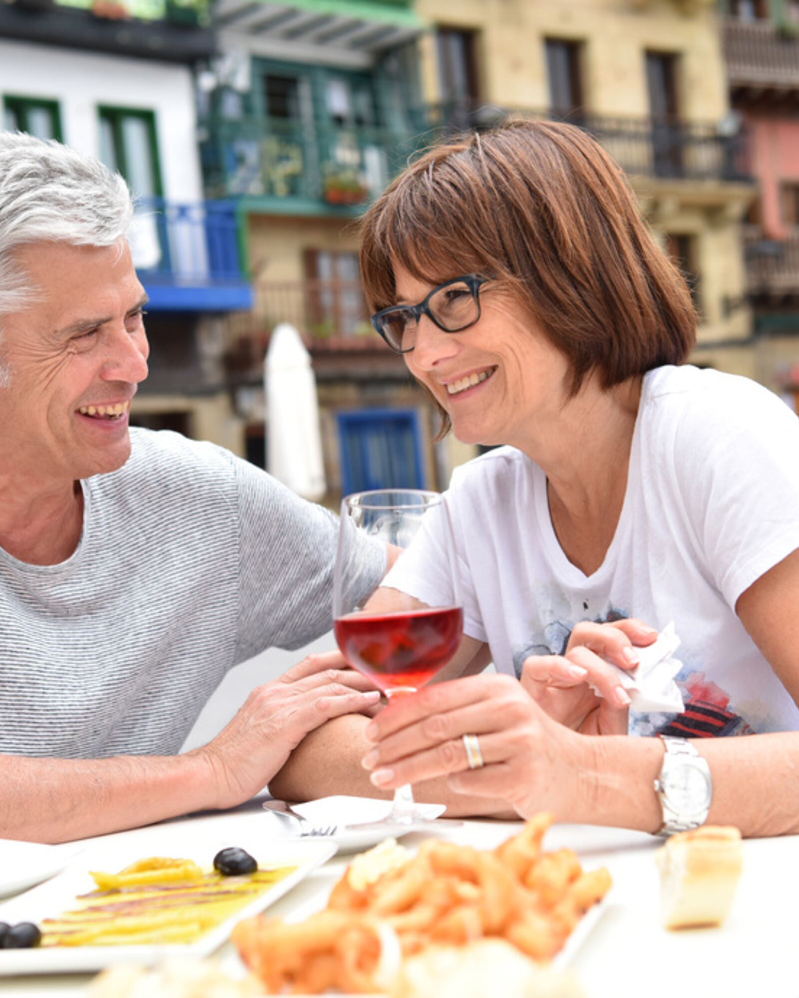 Couple enjoying tapas and wine at a Spanish plaza